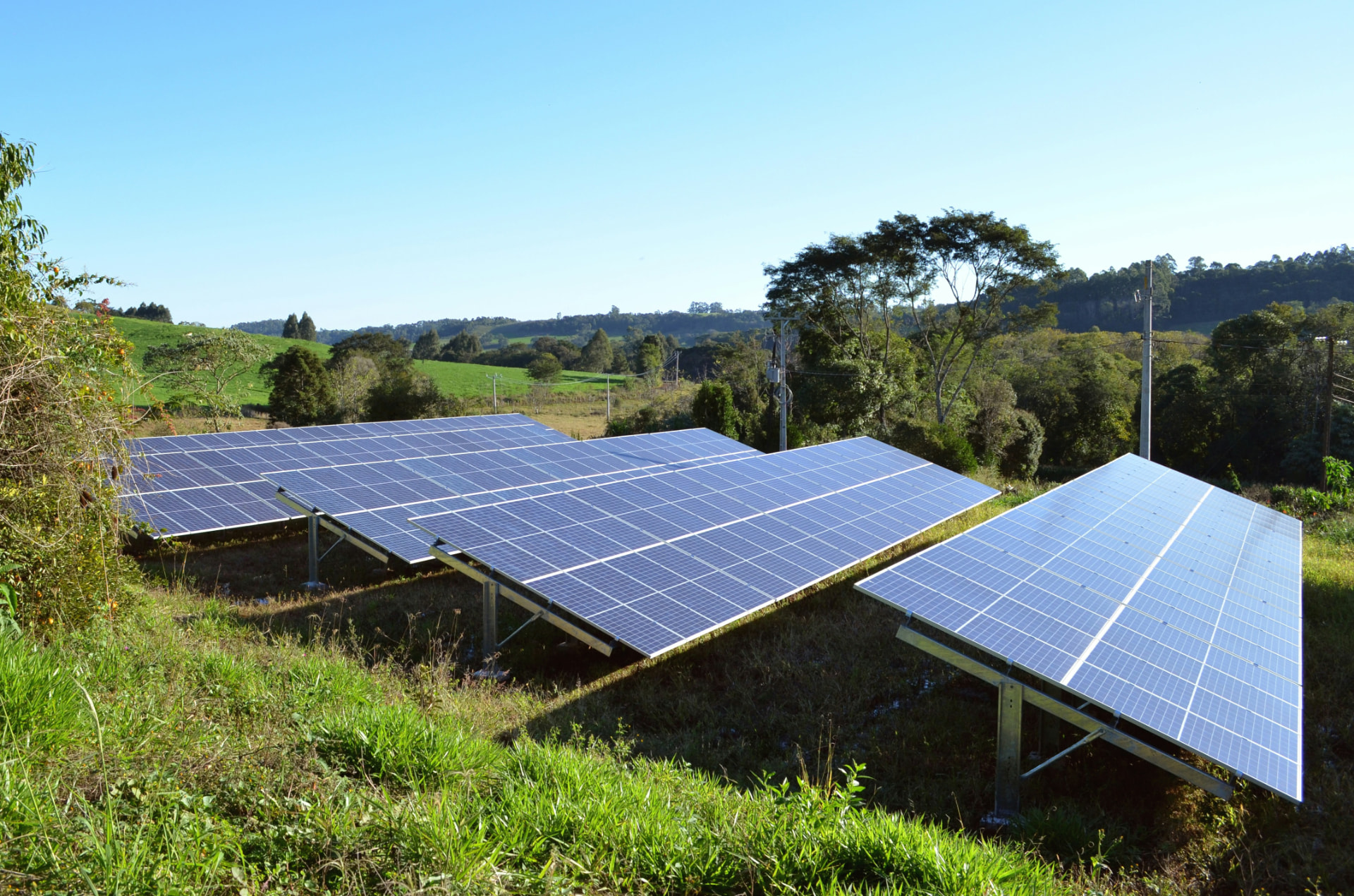 Fileiras de painéis solares instalados em solo, em área rural
